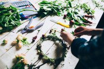 Hands making flower wreath — Stock Photo