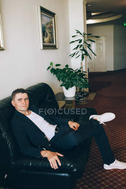 Bräutigam sitzt auf Sofa im Flur — Stockfoto