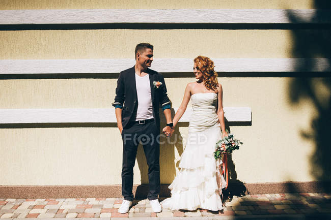 Coppia sposata in posa con mazzo di fiori — Foto stock