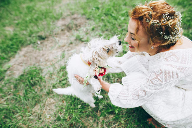Bride playing with dog — Stock Photo