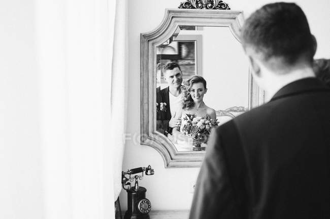 Casal casal posando no espelho — Fotografia de Stock