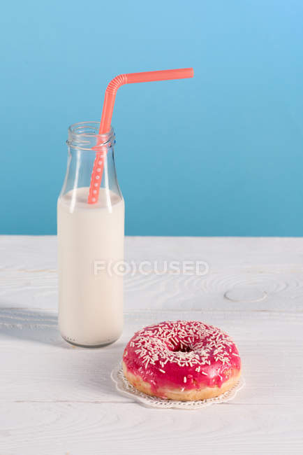 Garrafa de vidro de leite com donut no prato — Fotografia de Stock