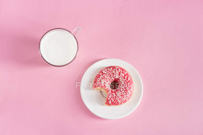 Copo de vidro de leite com donut na placa — Fotografia de Stock