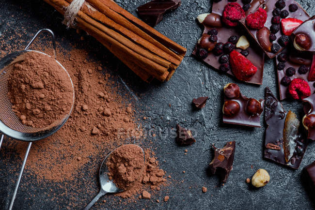 Pieces of chocolate with nuts and berries with cinnamon — Stock Photo