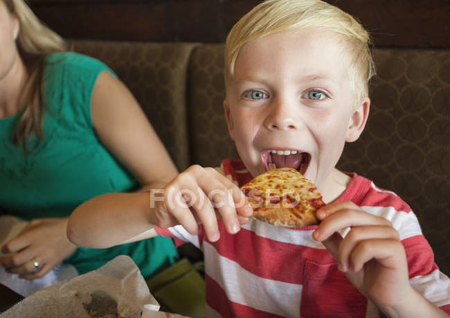 Garçon prenant biteof pizza — Photo de stock