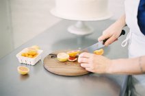Donna che taglia arance fresche — Foto stock