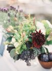 Blumenschmuck und Schale mit Pflaumen — Stockfoto