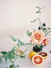 Fresh halved orange with roses — Stock Photo