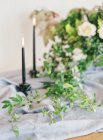 Candles lighting and floral arrangement — Stock Photo