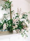 Огорожа з троянд і бузкових квітів у вазі — стокове фото