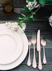 Plates and cutlery on wooden table — Stock Photo
