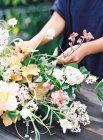 Fleuristes mains organiser des fleurs dans le bouquet — Photo de stock