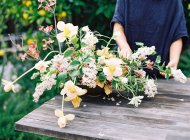 Floristas manos organizando flores en ramo - foto de stock