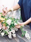 Floristas manos establecer ramo de flores - foto de stock