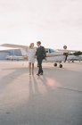 Paar läuft Händchenhaltend am Flugplatz — Stockfoto