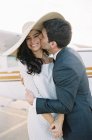 Мужчина обнимает и целует женщину на аэродроме — стоковое фото