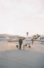 Casal de pé ao lado de avião pequeno — Fotografia de Stock