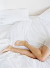 Schöne weibliche Beine im Bett — Stockfoto