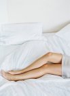 Красивые женские ноги в постели — стоковое фото