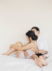 Giovane coppia seduta e rilassante a letto — Foto stock