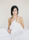 Полуодетая женщина тянет одеяло — стоковое фото