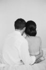 Mann umarmt Frau auf Bett — Stockfoto