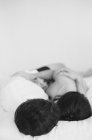Hombre y mujer abrazándose en la cama - foto de stock