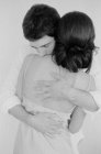 Hombre y mujer abrazándose en el dormitorio - foto de stock