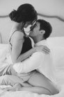 Uomo e donna che si abbracciano a letto — Foto stock