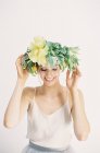 Mujer ajustando corona de flores - foto de stock