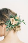 Fleurs élégantes dans les cheveux de femme — Photo de stock