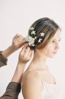 Styliste ajoutant des fleurs aux cheveux — Photo de stock
