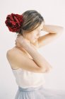 Frau mit roten Blumen im Haar — Stockfoto
