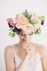 Femme en couronne de fleur doigt mordant — Photo de stock