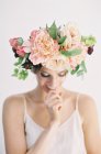 Woman in floral crown biting finger — Stock Photo