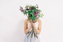 Mulher em tule vestido com flores lilás — Fotografia de Stock