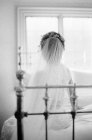 Bride sitting on bed and looking away — Stock Photo