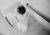 Donna in abito da sposa salendo le scale — Foto stock