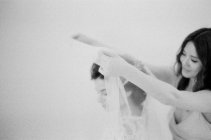 Женщина помогает невесте с покрывалом — стоковое фото