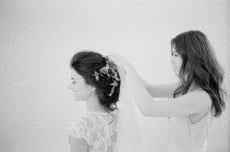 Mujer ayudando novia con la decoración del cabello - foto de stock