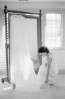 Mulher no vestido de noiva escolhendo sapato — Fotografia de Stock