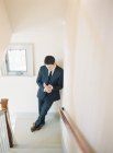 Man in suit standing on stairs — Stock Photo