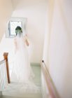 Mulher de vestido de noiva em pé nas escadas — Fotografia de Stock