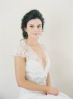 Frau im Hochzeitskleid blickt in die Kamera — Stockfoto
