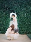 Mujer con flores ayudando novia - foto de stock