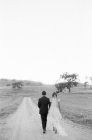 Pareja recién casada caminando por sendero rural - foto de stock