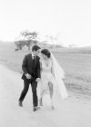 Casal recém-casado andando em campo — Fotografia de Stock