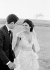 Recém-casados caminhando em campo — Fotografia de Stock