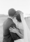 Пара в свадебной одежде обнимается на открытом воздухе — стоковое фото