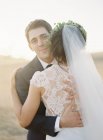 Recém-casados abraçando ao ar livre — Fotografia de Stock